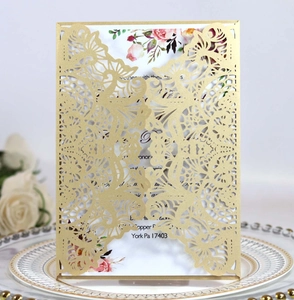 Detailed laser-cut gold wedding invitation featuring elegant floral patterns and a classic envelope