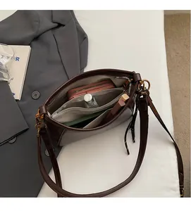 Dettaglio interno della borsa in pelle marrone scuro con tasca a zip e ampio spazio