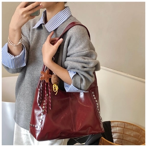 Détails du sac cabas bordeaux brillant avec clous argentés et pendentif étoile