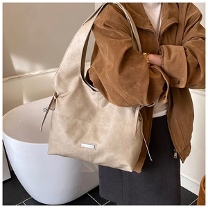 Detail of vintage tote bag with bow side accents and premium leather texture on model