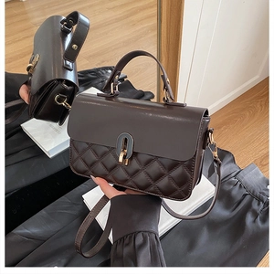 Detailed close-up of dark brown quilted handbag showing leather stitching and metal lock