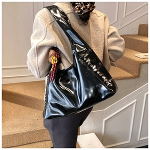 Détail du sac hobo noir brillant avec rivets argentés et pendentif ours mignon inclus
