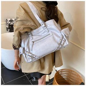 Detail of light gray motor-style tote bag with metal buckles and textured faux leather