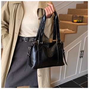 Detail of vintage black PU tote with silver metal hardware and smooth oil finish texture