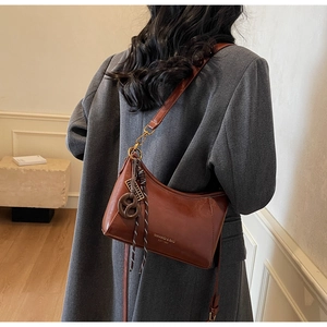 Dettaglio borsa a mezzaluna vintage marrone scuro con corda intrecciata e oro metallo