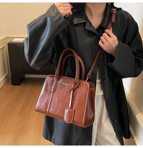 Brown vintage faux leather tote bag with gold logo and adjustable shoulder strap