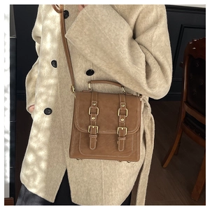 Brown vintage leather crossbody bag worn on a beige wool coat for chic autumn style