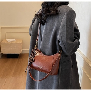 Detailed view of brown vintage wax leather hobo bag with minimalist shoulder strap