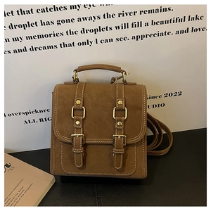 Detail shot of a brown vintage backpack featuring matte texture and gold buckle straps