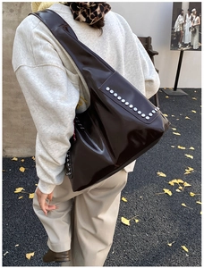 Détail du sac cabas en cuir verni marron chocolat avec clous argentés et grande capacité