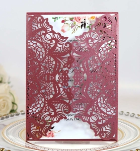Laser cut burgundy wedding invitation with elegant floral hollow texture on ceramic plate