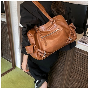 Close-up of vintage brown tote bag with multiple pockets and adjustable shoulder strap