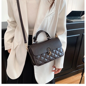 Brown quilted crossbody bag with gold twist lock and adjustable strap on elegant model