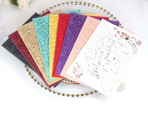 Detailed view of laser-cut wedding invitation covers in nine elegant colors on a tray