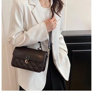 Detail view of a vintage quilted crossbody bag with golden metal twist lock and shoulder strap