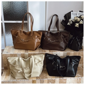 Dettaglio di quattro grandi borse tote in marrone, caffè, crema e nero con texture in pelle