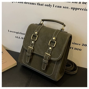 Detail of dark green matte vintage backpack with white contrast stitching and buckles