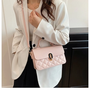 Close-up of pink quilted crossbody bag with gold metal clasp and elegant chain strap details