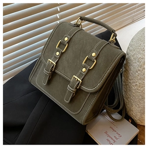 Detail of vintage olive green matte leather backpack with golden buckles on a suit
