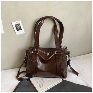 Detail view of dark brown PU leather tote bag featuring crossbody strap and silver hardware