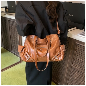 Detail of vintage brown PU leather tote bag with multi-pocket design and metallic buckles