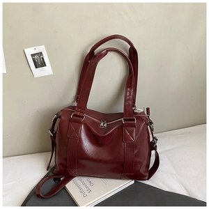Macro view of burgundy vintage tote bag featuring fine leather texture and silver hardware