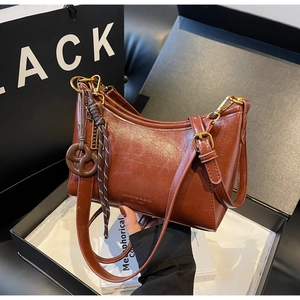 Brown leather hobo bag with woven charm and metal zipper in premium gift box