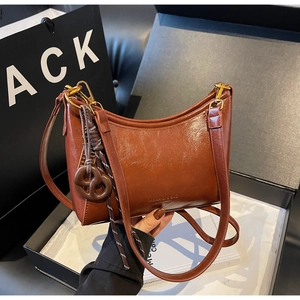 Brown vintage wax leather bag in gift box with biscuit charm and metallic hardware
