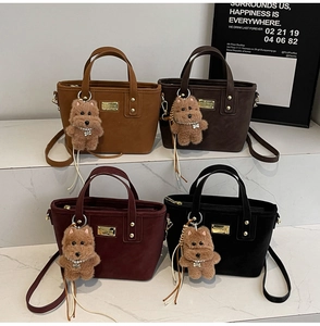 Detail of four colorful suede bucket bags featuring cute plush puppy charms and metal logos