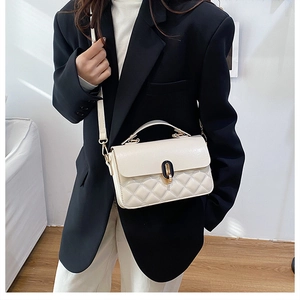 Classic cream quilted handbag styled with a black blazer and gold clasp detail