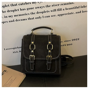 Detail view of vintage black mini backpack with white stitching and gold hardware accents