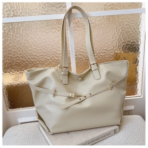 Dettaglio della borsa tote beige in ecopelle con fibbia dorata e cinturino decorativo