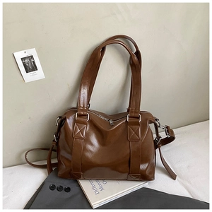 Close-up of a vintage dark brown tote bag with high-gloss finish and dual shoulder straps