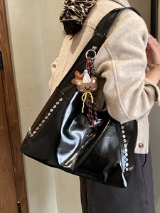 Sac fourre-tout noir brillant rétro avec clous argentés et ours suspendu sur modèle