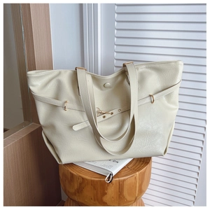 Dettaglio della grande borsa tote bianco sporco con finiture dorate e pelle PU testurizzata