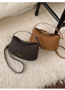 Close-up of vintage brown leather bucket bags with pebble texture and metal clasps