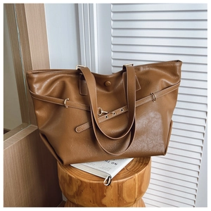 Dettaglio della borsa tote color caramello con fibbie regolabili e finiture metalliche