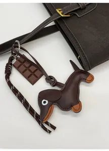 Detail of leather dachshund charm with chocolate pendant and woven rope on tote bag