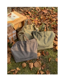 Detailed close-up of khaki, olive, and taupe canvas tote bags in an autumn outdoor setting