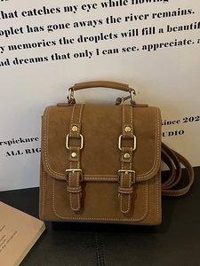 Vintage brown leather backpack with gold buckles and adjustable straps for women