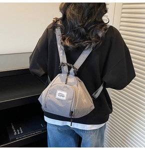 Detailed view of the gray checkered mini canvas backpack with branded woven label