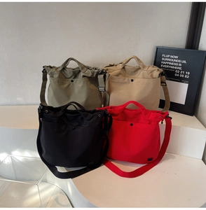 Detail of canvas crossbody bags in army green, beige, black, and red with front pockets