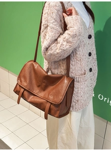 Detailed view of brown retro messenger bag with smooth PU leather and flap design