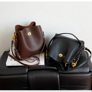 Close-up of pebble leather bucket bags with gold twist locks and adjustable straps