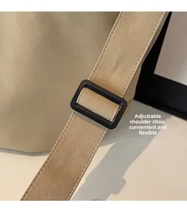 Detail of adjustable canvas shoulder strap with buckle on a beige minimalist bag