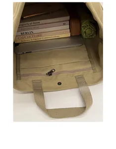 Top view detail of khaki canvas tote showing spacious interior with laptop and books