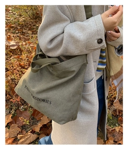 Detail of army green canvas tote bag with PANOR & STORIES print on textured fabric