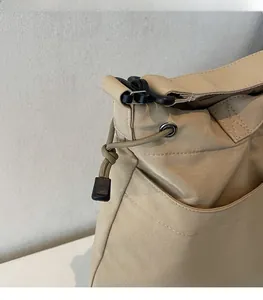 Detail of khaki nylon bag showing functional drawstring design and neat stitching