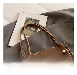 Detail of vintage brown patent leather bucket bag with gold dome rivet decorations