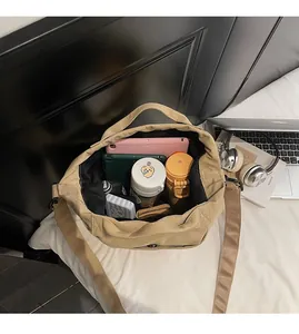 Macro view of khaki canvas shoulder bag showing large capacity and spacious interior